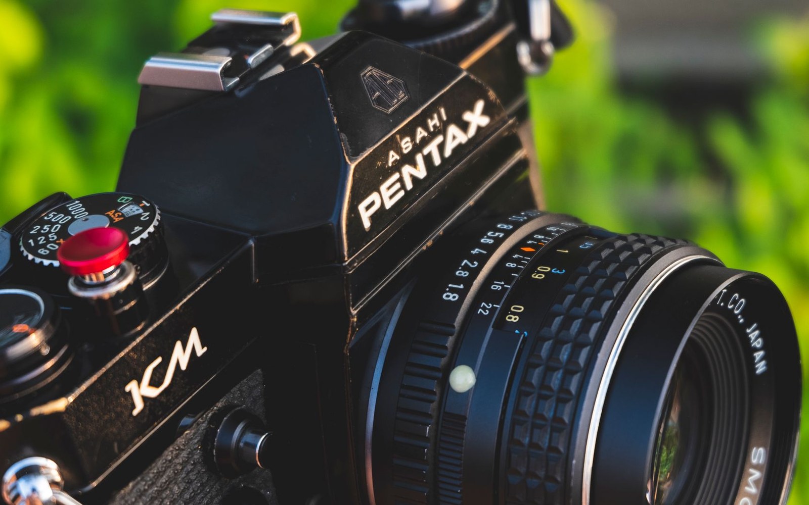 Close-up of a black Asahi Pentax KM camera body and lens with aperture ring